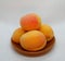 Ripe fragrant apricots on a small brown plate on a white background. Natural vitamin. Healthy food. vegetarian food.