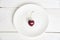 Ripe fresh juicy berry on a white background. One heart-shaped cherry on a white plate. Fruit background. valentine