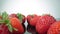 Ripe, fresh, natural strawberries in reflection, in extreme macro, close up. Movement forward, backward.