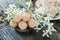 Ripe fresh pineberries in a pink Cup in a rustic style with small white flowers close-up