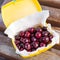 Ripe fresh tasty bio cherries in plastic lunchbox oudoors. Organic sweet berries takeaway quick food for picnic. Wooden table on b