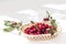 Ripe fruit cherry wicker basket on white desk. Red berry