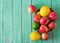 Ripe fruits (apples, lemons and limes) on a bright wooden background.