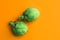 Ripe green artichokes on bright solid orange background. Creative food poster. Minimalist style. Mediterranean Spanish cuisine