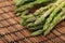 Ripe green mini asparagus on wooden mat
