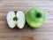 Ripe green and red apple whole and half piece on wooden background