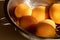 Ripe juicy apricots in a metal colander on a light wooden table in the sun. Close up