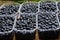 Ripe juicy blueberries in plastic containers on market stall. Fresh organic berries from ecofarm