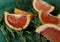 ripe juicy fragrant grapefruit cut into slices lies on fresh green fragrant and healthy