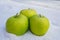Ripe and juicy green apples on cold snow