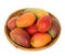 Ripe juicy mangoes in a round bamboo tray