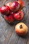 Ripe juicy organic vibrant red pomegranates in metal wicker basket on reclaimed plank barn wood background