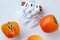 Ripe juicy persimmon and macrame panels on a white background