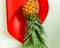 Ripe, juicy pineapple on a light background, wrapped in a red bag. Bright summer image. To close. Free space.