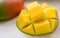 Ripe juicy yellow exotic mango cut into cubes on wooden background. Tropical delicacy full of vitamins for a healthy