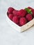 Ripe large raspberry and a sprig of mint in a bowl in the shape of a heart