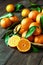 Ripe Mandarin fruit peeled open and place on old rustic look timber with group of mandarin fruits and leaves out of focus on the