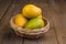 Ripe mango in basket on wooden table. Group of fresh mango. Ripe yellow mangoes on wooden background