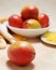 Ripe mangos in a bowl with plate of cut fruit on a softly colored table cloth