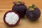 Ripe mangosteens Garcinia mangostana or half mangosteen on a wooden table