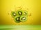 Ripe natural green kiwis, cut into slices, fly in the air with drops of water on a yellow background, fruit levitation