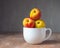Ripe nectarines in a white ceramic mug on a wooden table