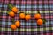 Ripe orange madarins tangerines with green leaves on a textile multicolored colorful tablecloth. Fruit, citrus, tropical, health