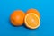 Ripe oranges on a blue background. Juicy half orange.