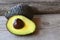 Ripe organic avocado half and whole fruits on wooden background with copy space.