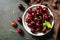 Ripe organic berry. Fresh Red sweet cherry on plate on a dark stone tabletop. Top view flat lay background.