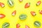 Ripe Organic Halved Strawberries and Kiwis Scattered on Bright Yellow Background in Pattern. Vibrant Colors