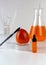 Ripe organic persimmon fruit and persimmon extract in cosmetic bottle with dropper. Abstract chemical or cosmetic laboratory