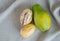 A ripe papaya and two pepino melons on a linen cloth