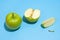 Ripe parts green apple Isolated on a blue background. Healthy eating and dieting concept