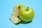 Ripe parts green apple Isolated on a blue background. Healthy eating and dieting concept