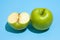 Ripe parts green apple Isolated on a blue background. Healthy eating and dieting concept