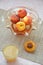 Ripe peaches and glass of juice on a table, cut peach, of a beautiful vase in the shape of a basket background.