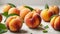 Ripe peaches with green leaves on a white background.