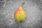 Ripe pear on a variegated gray background