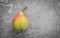 Ripe pear on a variegated gray background