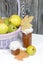 Ripe pears of the new harvest in a wicker basket. On boards painted white. Jam in jars, dried maple leaves