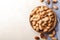 Ripe pecan nuts in dish served on light table, flat lay