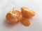 Ripe peeled mandarin orange. Fruit abstract composition on a white background.