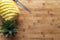 Ripe perfectly peeled pineapple, on a wooden background, space for text