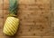 Ripe perfectly peeled yellow pineapple, on a wooden background.