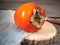 Ripe persimmon, wooden disk, denim napkin, on the old wooden board table.