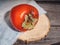 Ripe persimmon, wooden platter, denim, on an old wooden table.