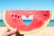 Ripe piece of watermelon with heart shape hole in female hands on the background of the beach on a hot summer day.