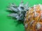 Ripe pineapple on a green background lateral closeup