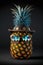 Ripe pineapple in hat with sunglasses on black background. Palm and sky reflection in mirror sunglasses. AI generative